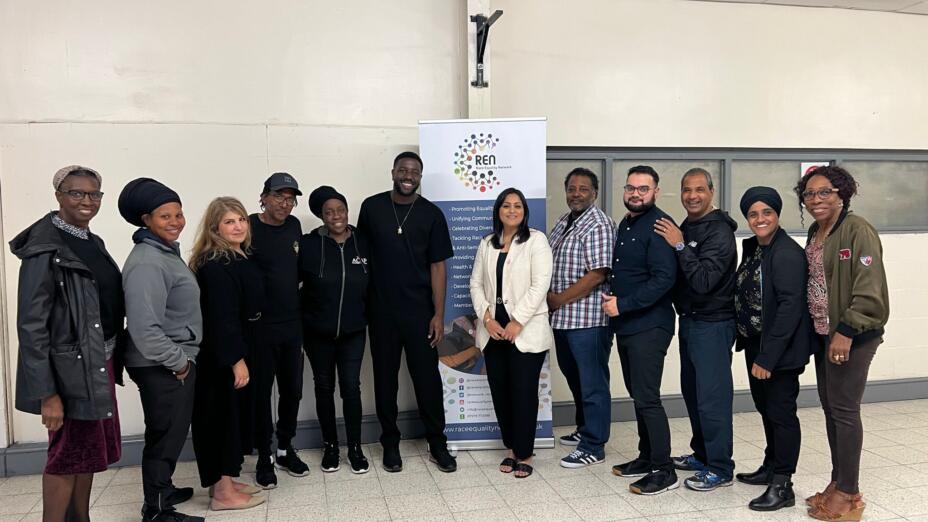 A group of young people standing and smiling to the camera.