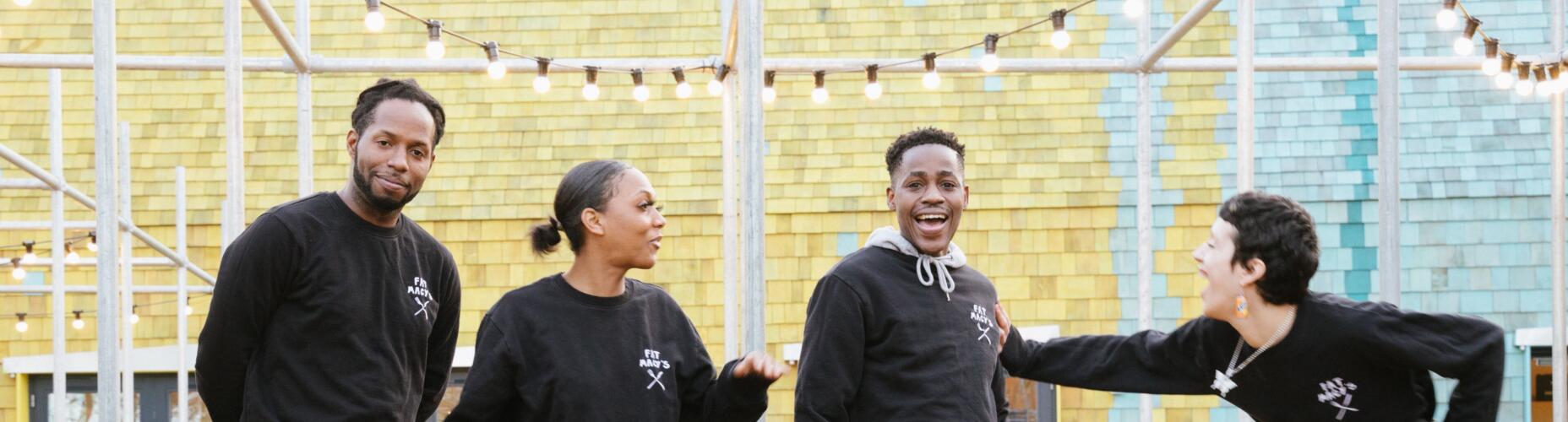 Four young people are standing and posing for a photo. One person is laughing and being playfully pushed by another Photo credit: Benoit Grogan Avignon