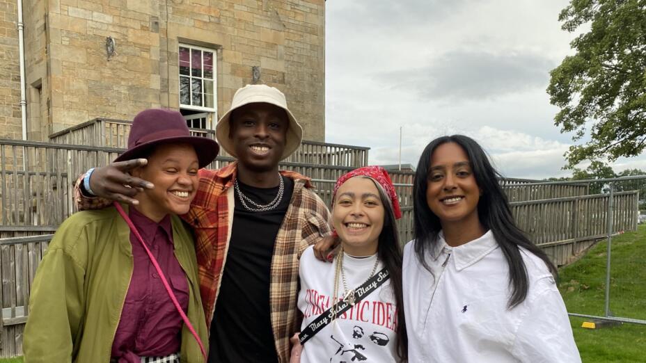 Four young people involved in Intercultural Youth Scotland smile outdoors during Connect Festival.
