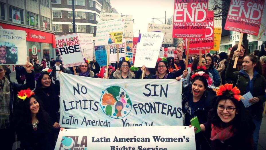 Picture of women from Latin American Women's Rights Service at a demonstration holding a white banner that reads: No limits / Sin fronteras