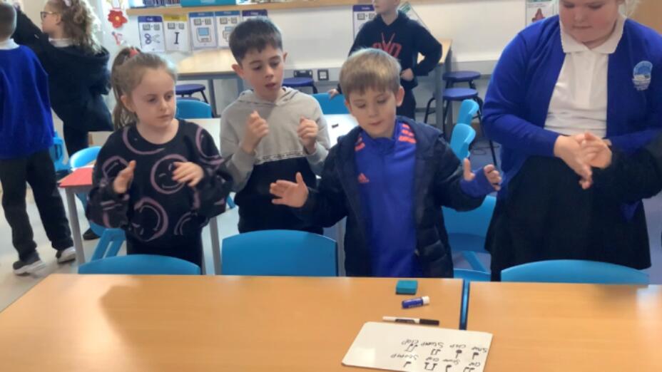 A group of pupils in blue school uniforms take part in an arts-based learning session.