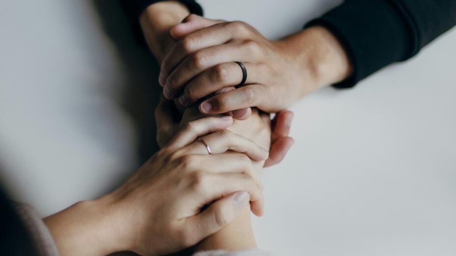 Two people holding hands across a table