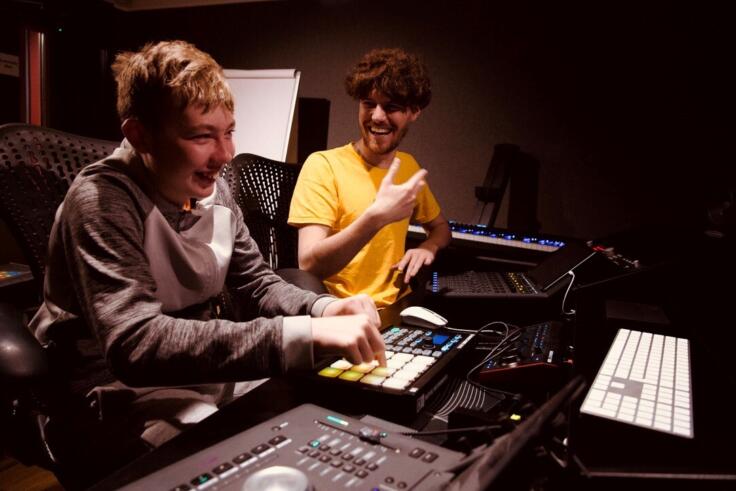 Young person and music leader making music at a recording studio at The Music Works.